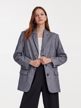 A lady wears a grey oversized blazer.